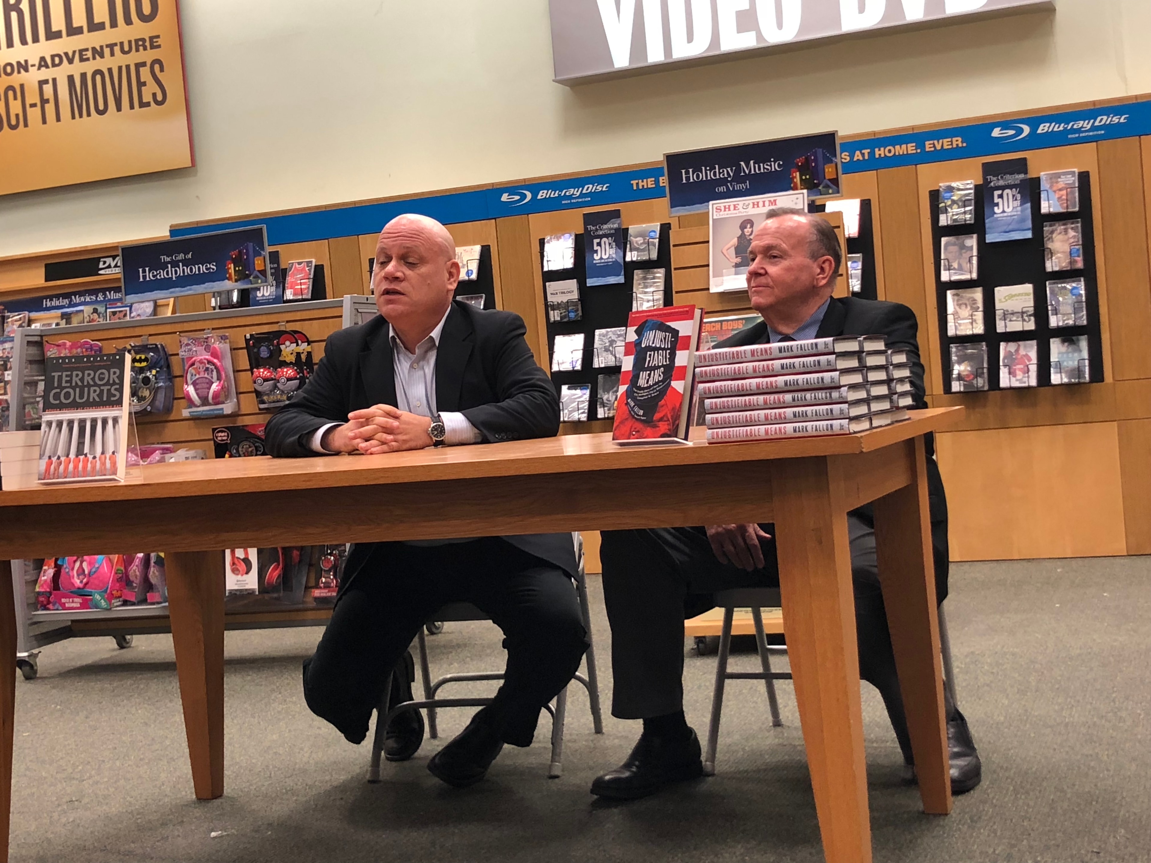 Mark Fallon and a colleague at a Barnes & Noble panel discussion with stacks of Unjustifiable Means on the table