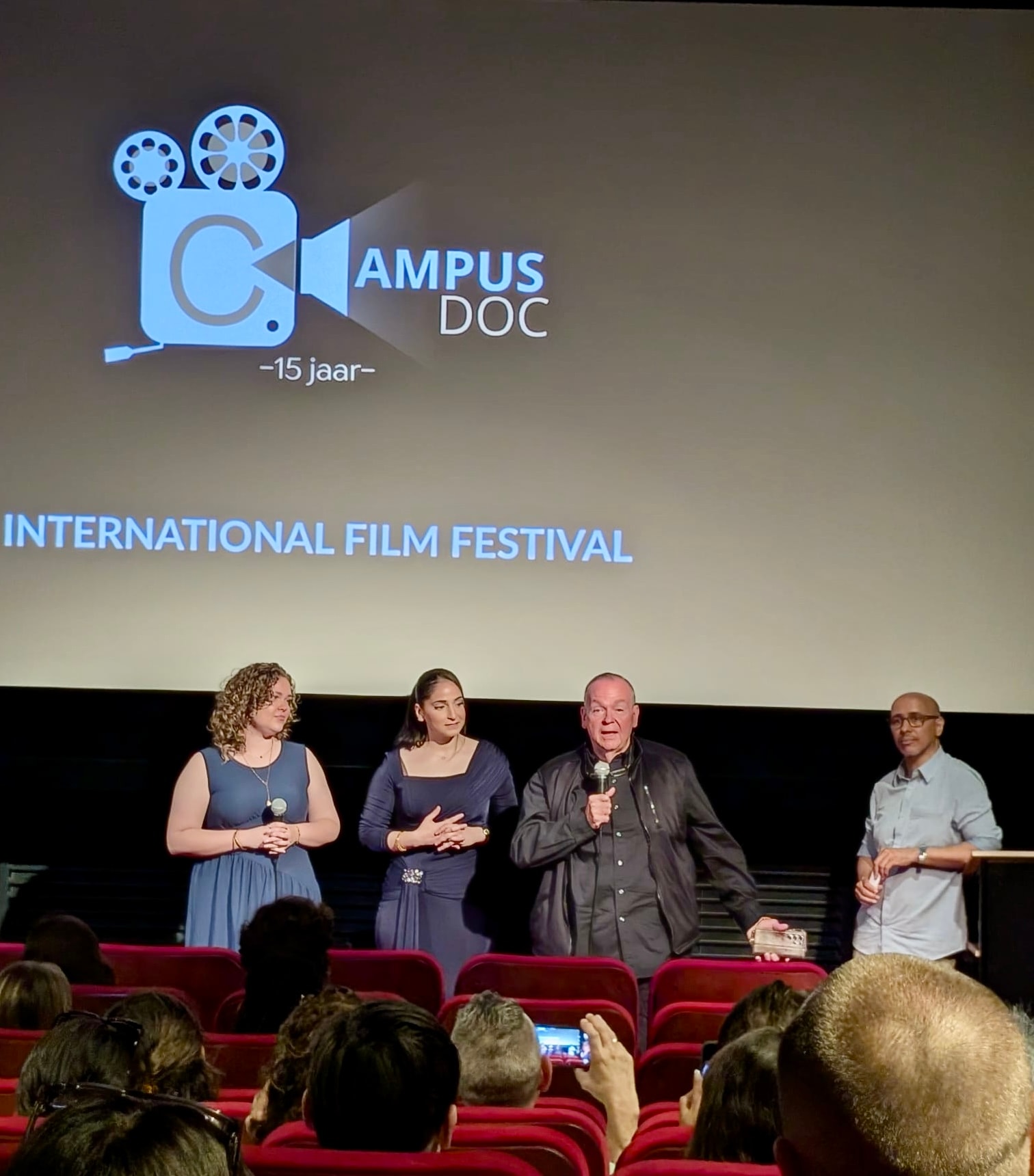 Mark Fallon speaking on stage at the Campus Doc International Film Festival 15th anniversary
