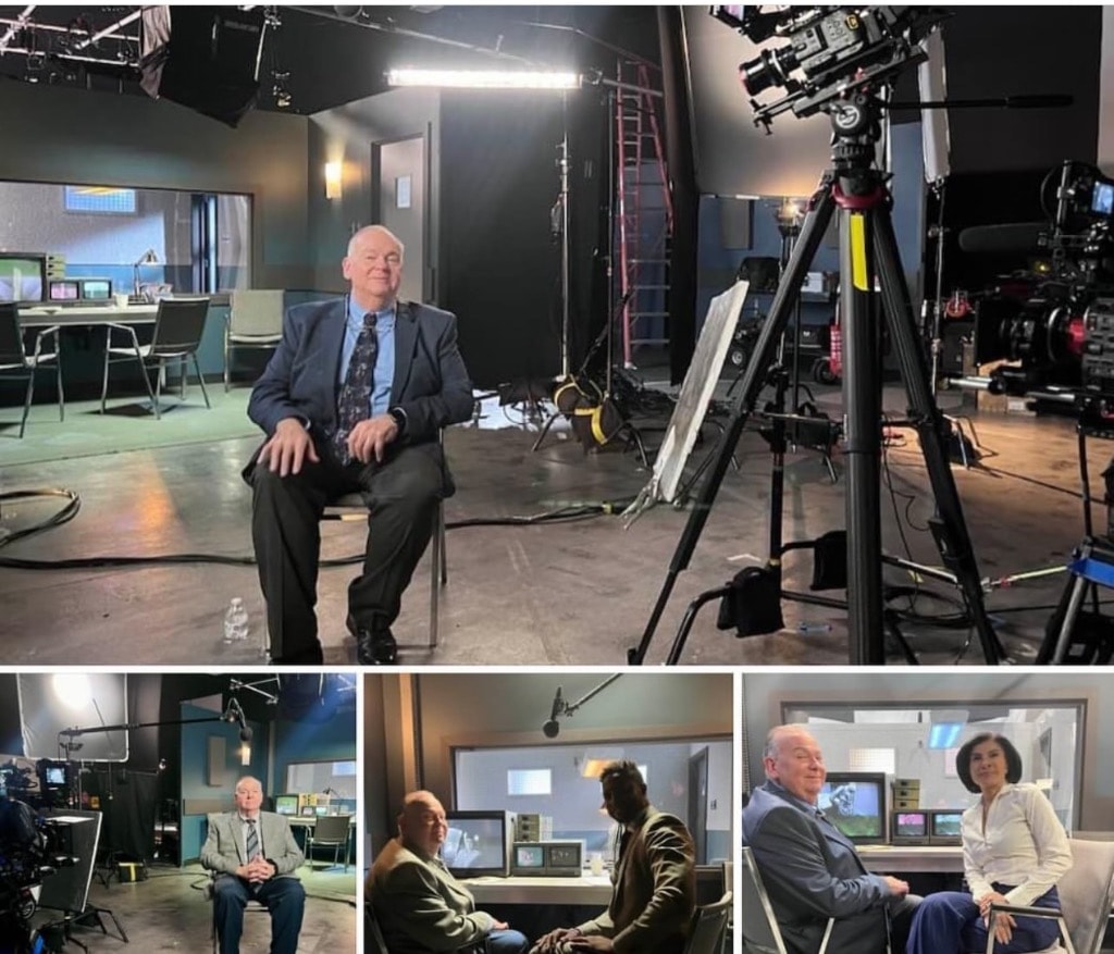Wide shot of Mark Fallon being filmed in a hotel conference room with GVM lighting and camera crew