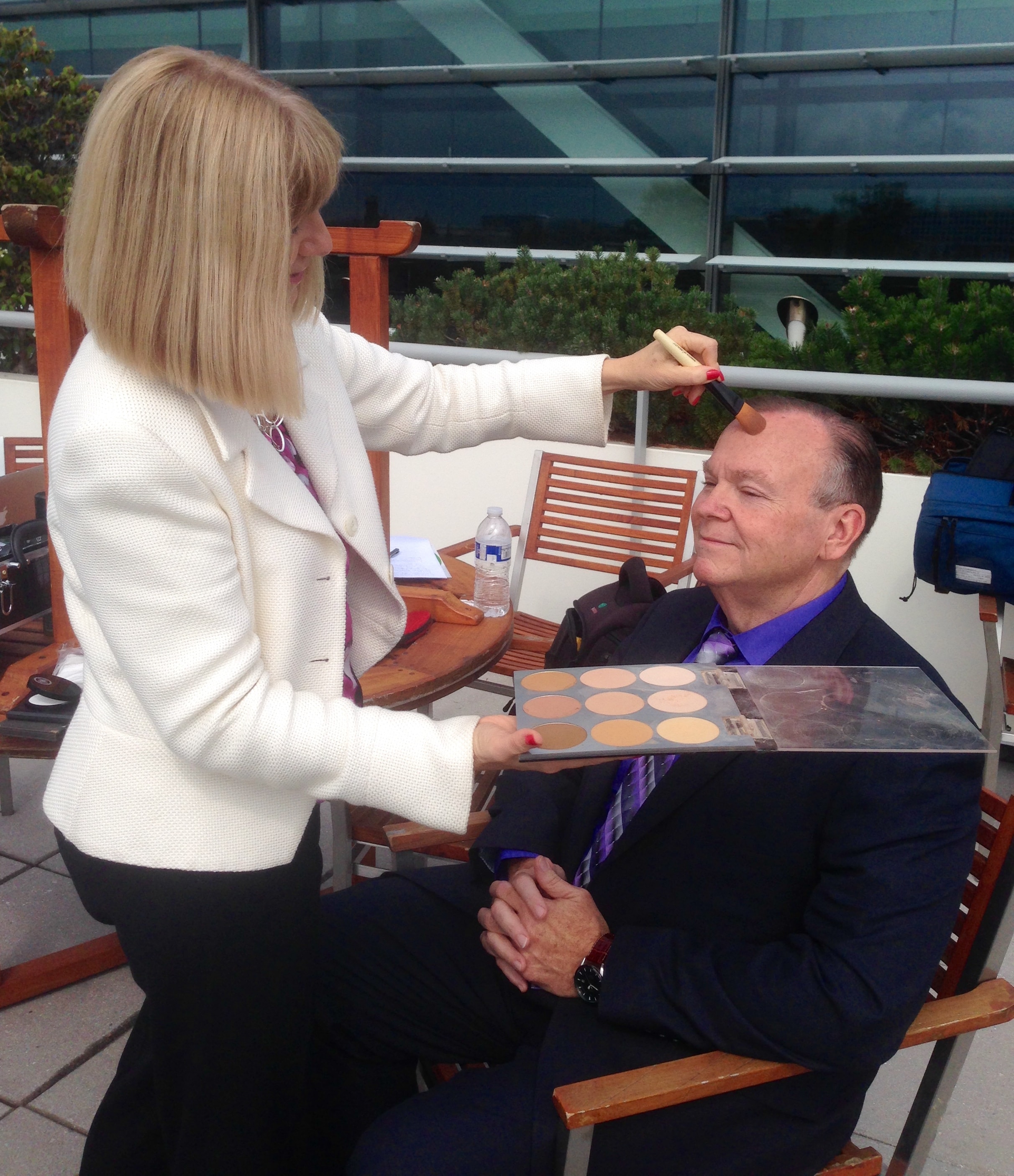 Mark Fallon getting makeup applied outdoors before a shoot