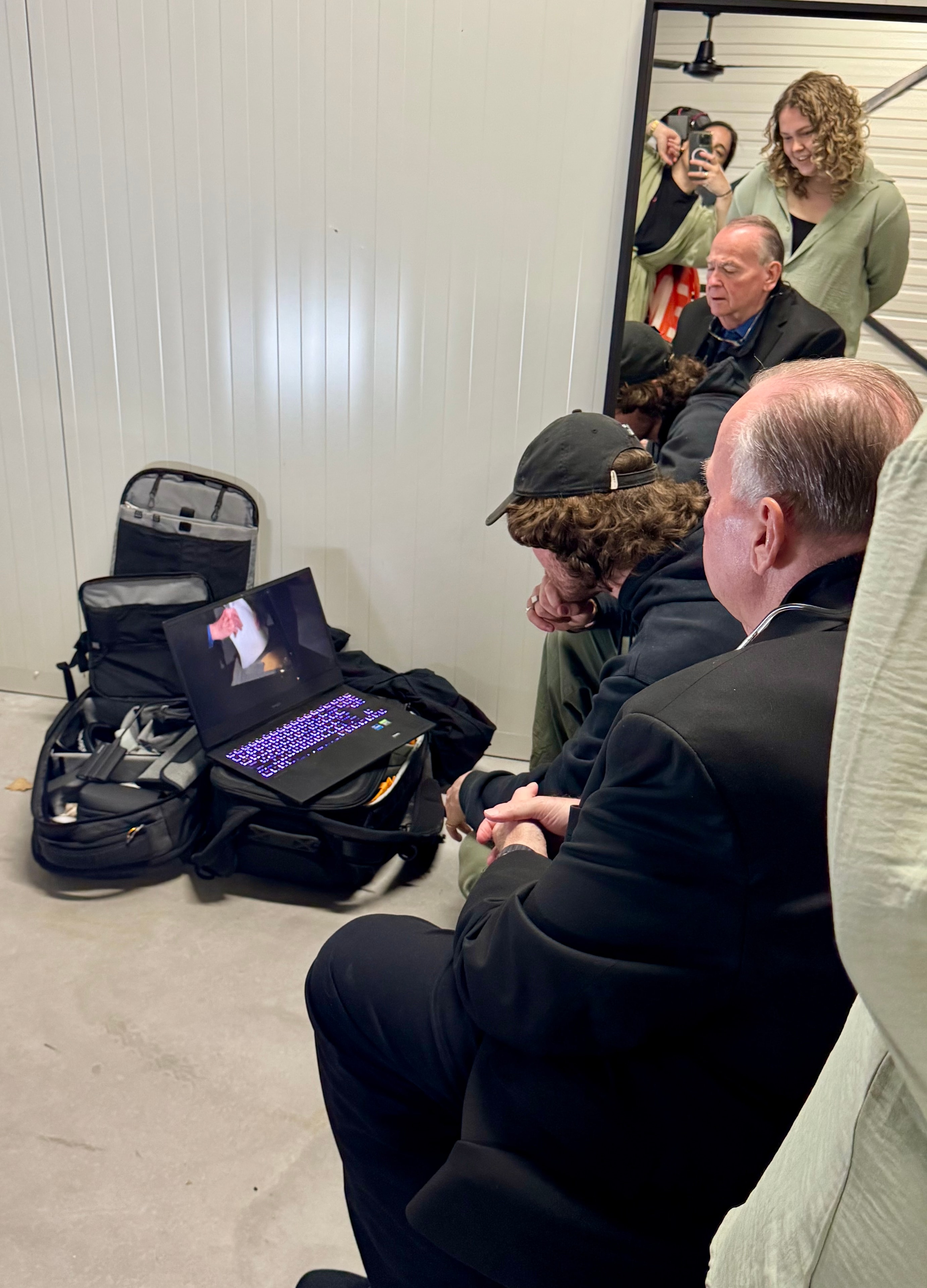 Mark Fallon and film crew huddled around a laptop reviewing playback footage on set