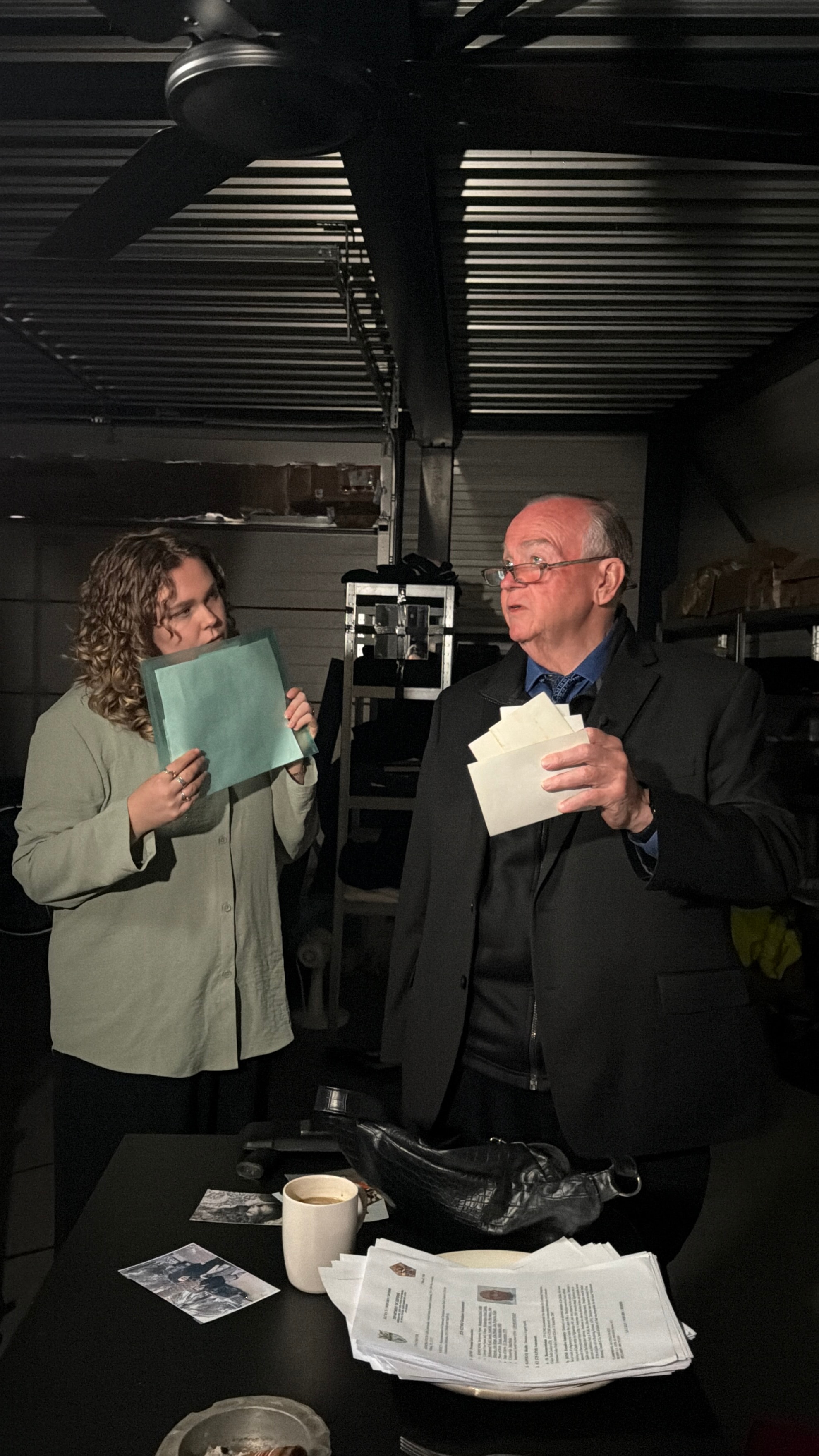 Mark Fallon and a crew member reviewing documents on a documentary film set